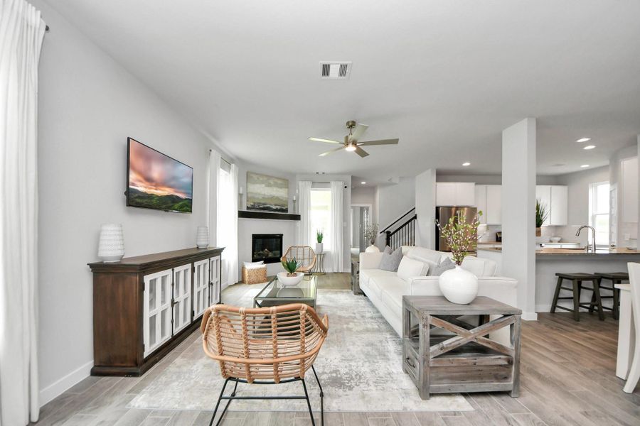 Welcome family and guests to your charming living room! With its high ceilings, recessed lighting, ceiling fan, custom paint, beautiful flooring, and large windows that let in abundant natural light, this room is perfect for gatherings. Welcome family and guests to your charming living room! With its high ceilings, recessed lighting, ceiling fan, custom paint, beautiful flooring, and large windows that let in abundant natural light, this room is perfect for gatherings.