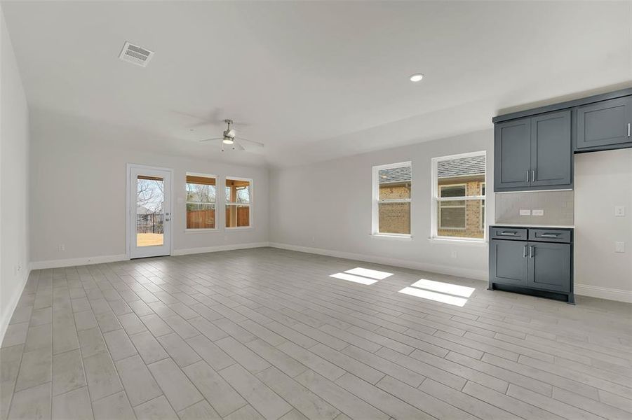 Unfurnished living room featuring recessed lighting, visible vents, a ceiling fan, light wood-style floors, and baseboards Unfurnished living room featuring recessed lighting, visible vents, a ceiling fan, light wood-style floors, and baseboards