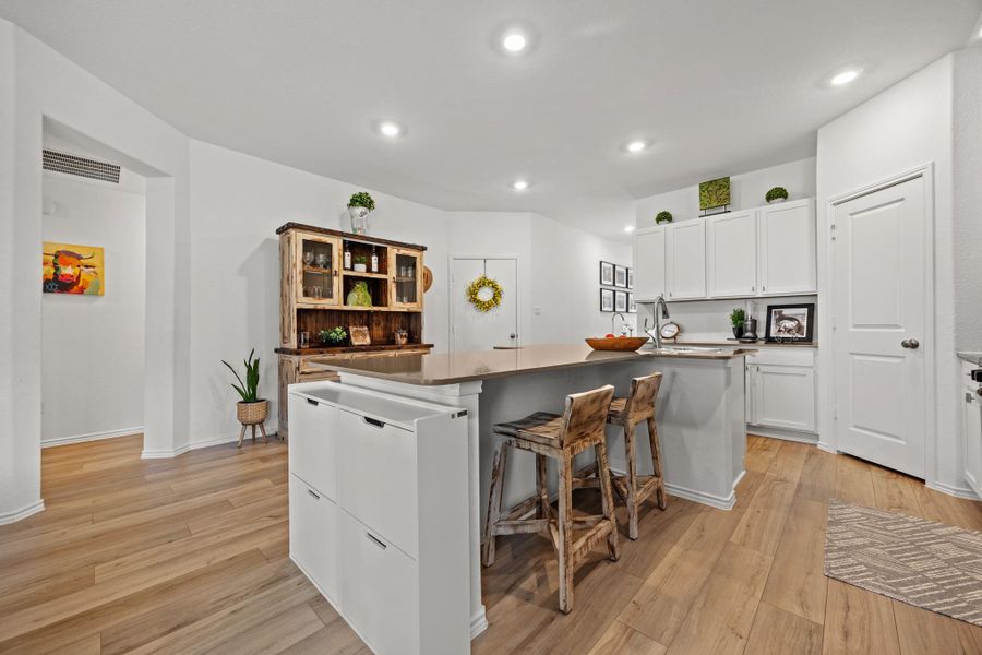 A well-lit culinary space features an inviting kitchen island and contemporary recessed lighting. A well-lit culinary space features an inviting kitchen island and contemporary recessed lighting.