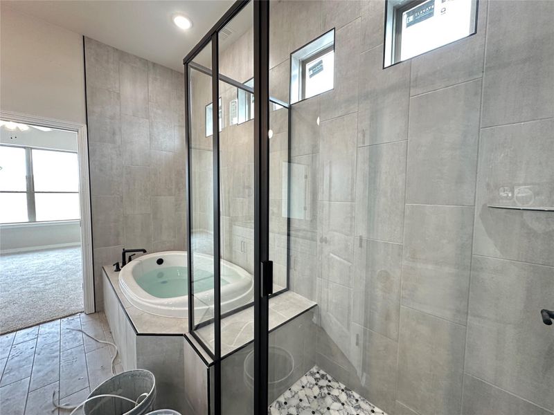 Bathroom with healthy amount of natural light, a stall shower, and a jetted tub