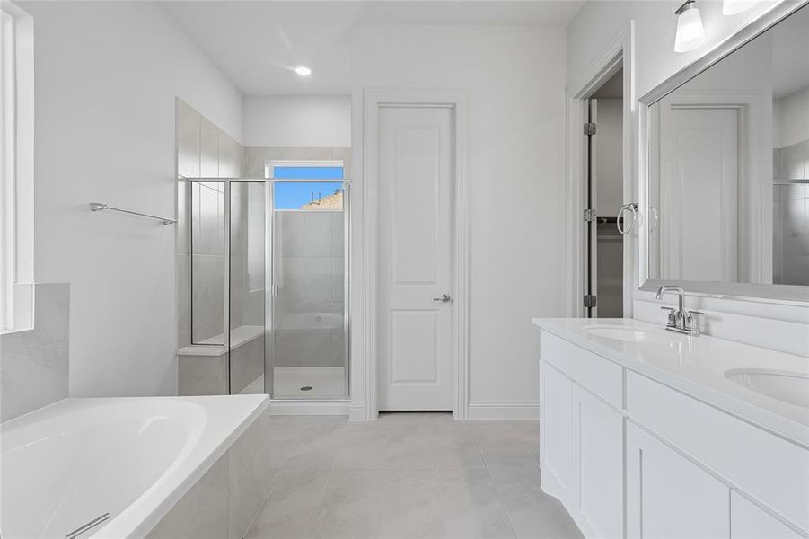 Full bathroom with a stall shower, a garden tub, double vanity, light tile patterned flooring, and a closet