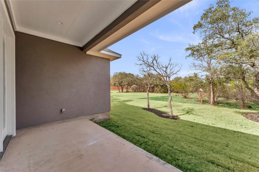 View of grassy yard with a patio area