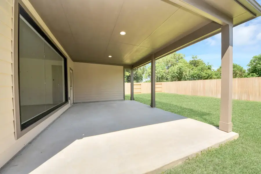 Experience outdoor living at its finest on this expansive covered patio, thoughtfully designed for BBQs and delightful outdoor dining. Sample photo of completed home with similar floor plan. Actual colors and selections may vary.