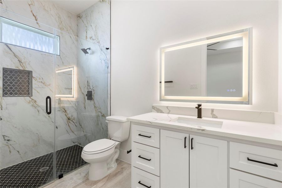 On-suite bath for bedroom 2 offers a stand up shower with designer tile, black hardware, and a lighted mirror. On-suite bath for bedroom 2 offers a stand up shower with designer tile, black hardware, and a lighted mirror.