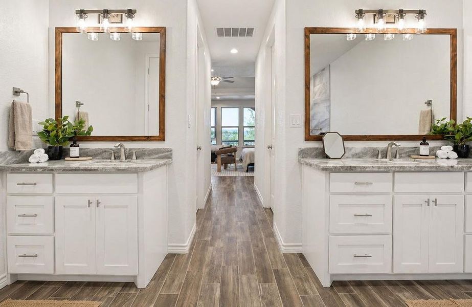 Twin vanities with marble countertops and undermount sinks define this bright, functional bathroom space.