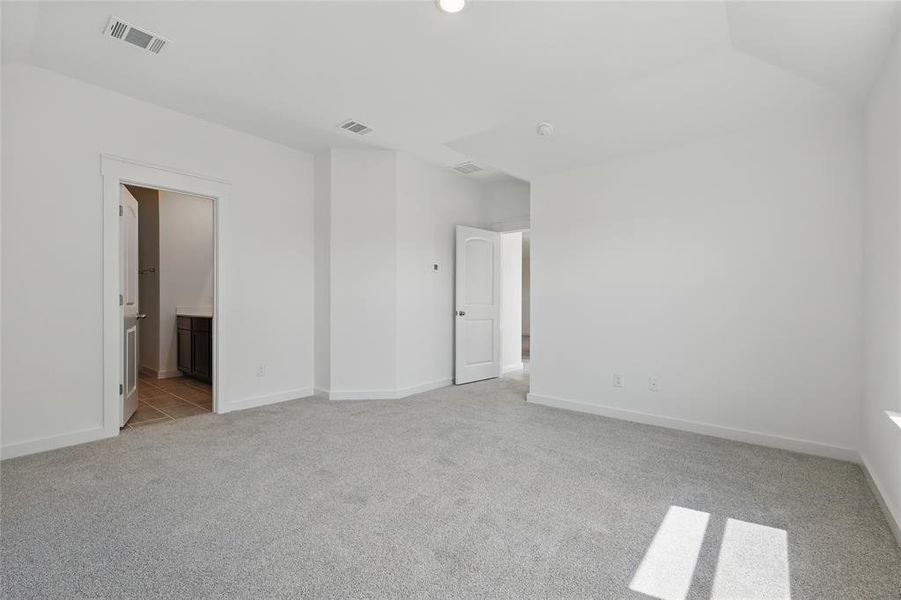 Unfurnished bedroom featuring light carpet and ensuite bath