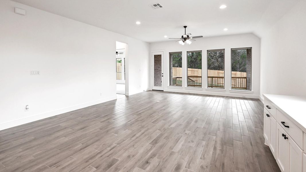 Unfurnished living room with a ceiling fan, light wood-type flooring, recessed lighting, and baseboards Unfurnished living room with a ceiling fan, light wood-type flooring, recessed lighting, and baseboards