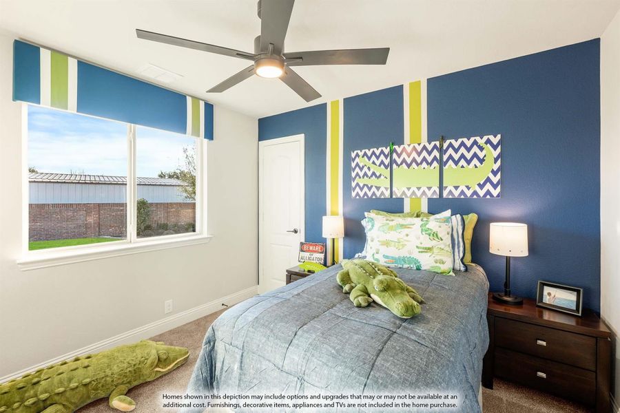 Child's bedroom with blue accent wall, ceiling fan, and alligator-themed bedding and decor Child's bedroom with blue accent wall, ceiling fan, and alligator-themed bedding and decor