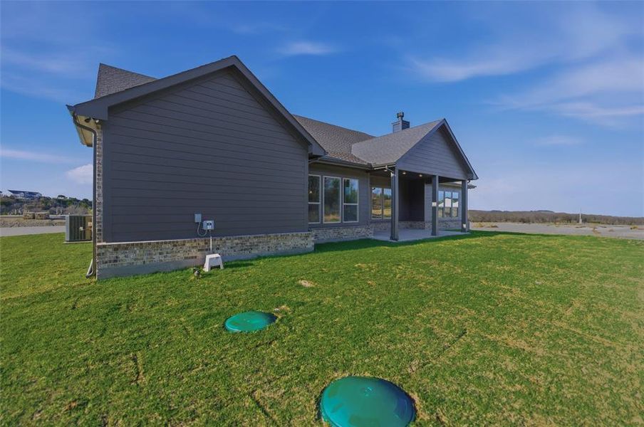 Back of house with a patio and a yard