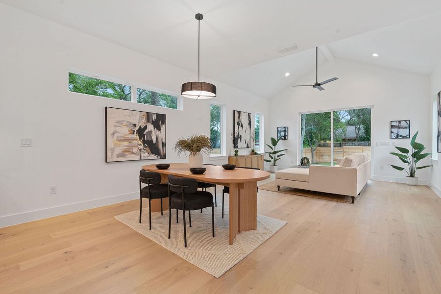 Dining room with high vaulted ceiling, light wood-type flooring, ceiling fan, and recessed lighting Dining room with high vaulted ceiling, light wood-type flooring, ceiling fan, and recessed lighting
