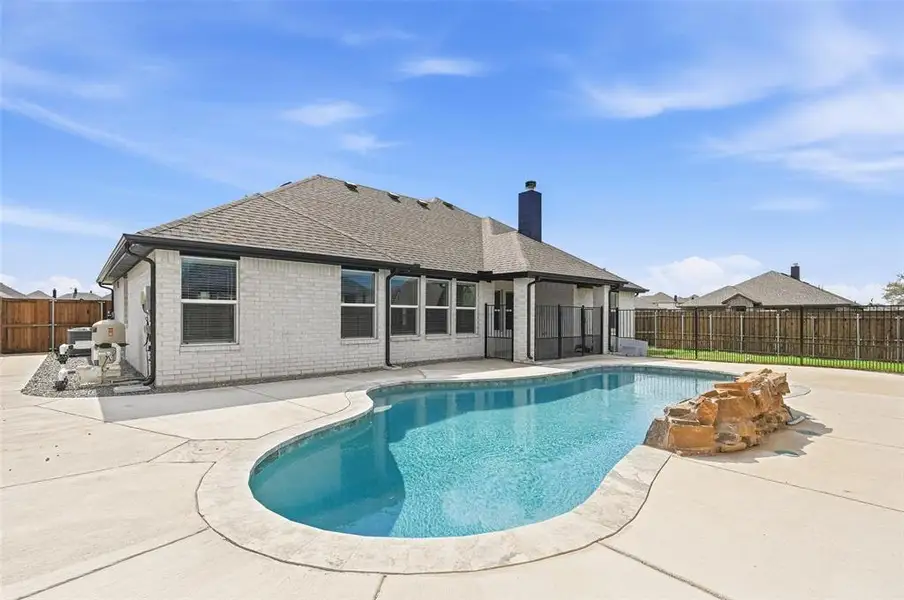 View of swimming pool featuring a fenced backyard, patio surround, and a sunroom View of swimming pool featuring a fenced backyard, patio surround, and a sunroom