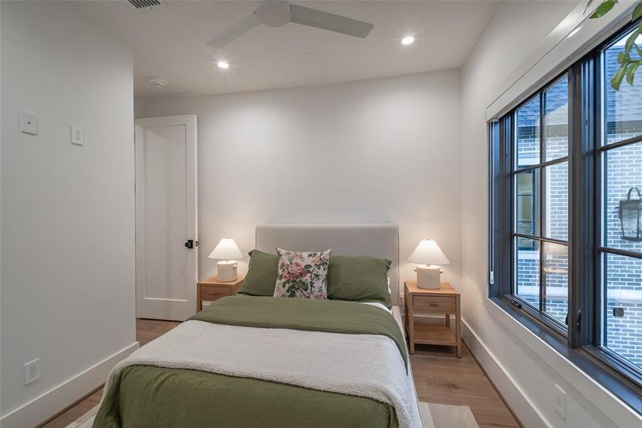 Bedroom featuring multiple windows, hardwood / wood-style flooring, and ceiling fan