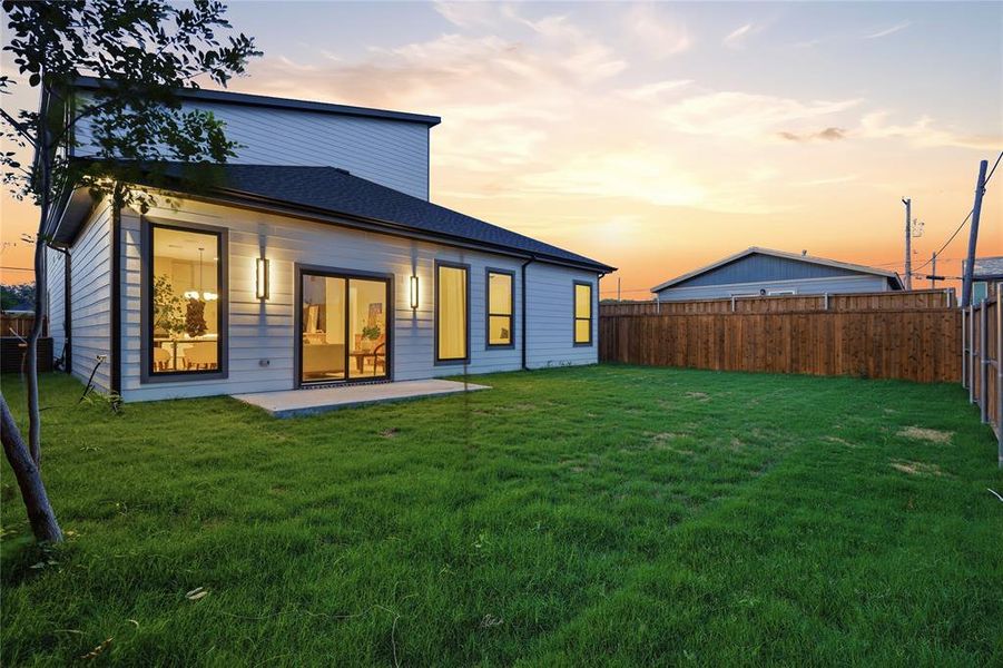 Spacious backyard featuring a concrete patio, wood privacy fencing, and a contemporary exterior with siding