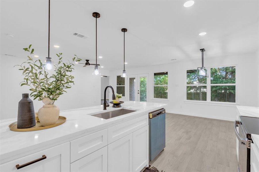 Kitchen with dishwashing machine, white cabinets, pendant lighting, recessed lighting, and light wood-style floors