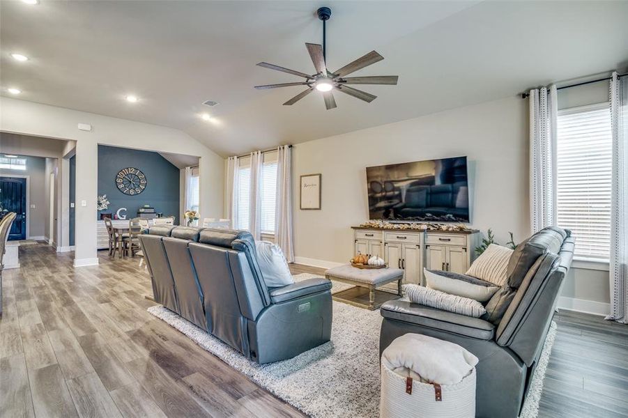 Living room featuring lofted ceiling, light hardwood / wood-style floors, and ceiling fan