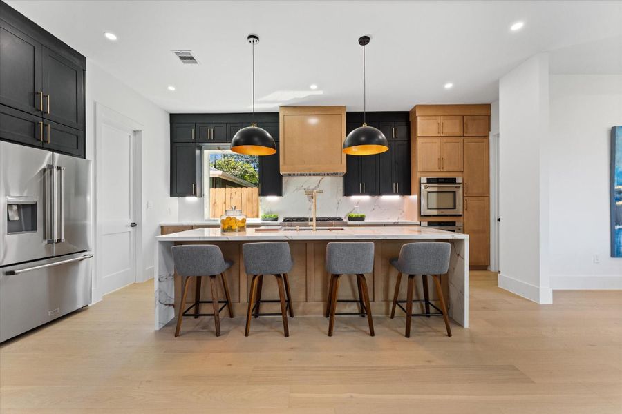 Sleek, modern kitchen featuring a spacious island with seating, stylish pendant lighting, and high-end appliances. Perfect for entertaining and culinary creativity. Sleek, modern kitchen featuring a spacious island with seating, stylish pendant lighting, and high-end appliances. Perfect for entertaining and culinary creativity.