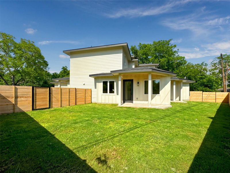 Rear view of house with board and batten siding and a patio Rear view of house with board and batten siding and a patio