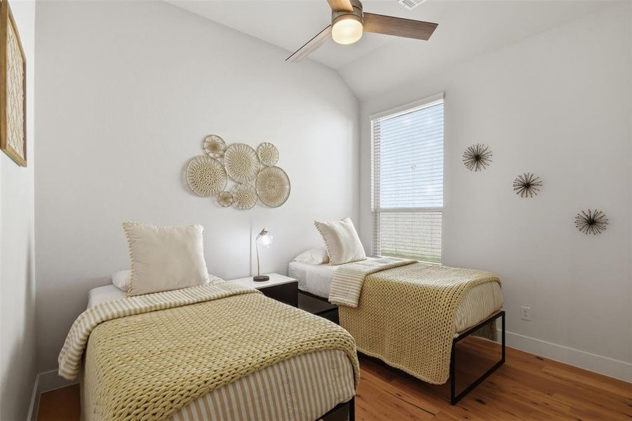 Room featuring high vaulted ceiling, wood-finish flooring, a contemporary ceiling fan with integrated lighting, and a large window with blinds Room featuring high vaulted ceiling, wood-finish flooring, a contemporary ceiling fan with integrated lighting, and a large window with blinds