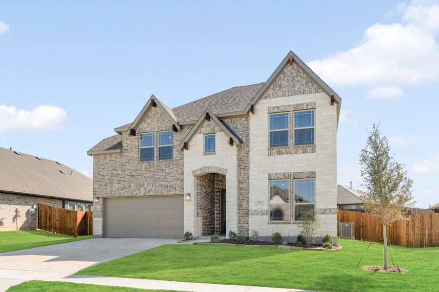 Two-story home with brick and stone exterior, two-car garage, and arched front entry on a green lawn Two-story home with brick and stone exterior, two-car garage, and arched front entry on a green lawn