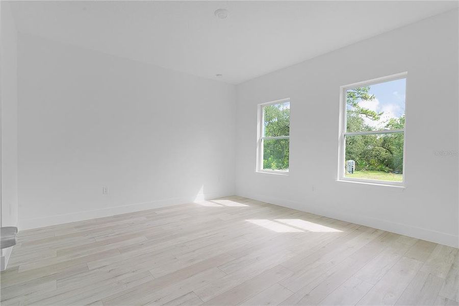 Primary bedroom with double windows toward the backyard