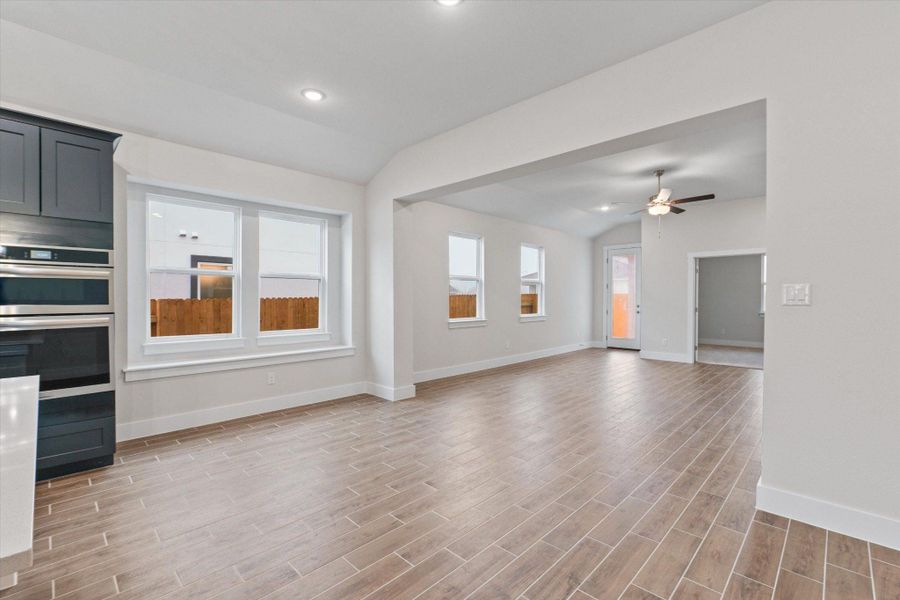 A well-lit, open-concept living area with integrated kitchen features elegant tile flooring.