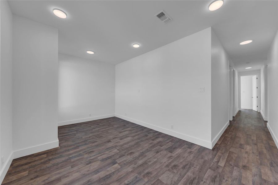 Entry flex/office space at front of home.  Recessed lighting illuminates clean white walls and durable wood-look flooring throughout this versatile interior space.