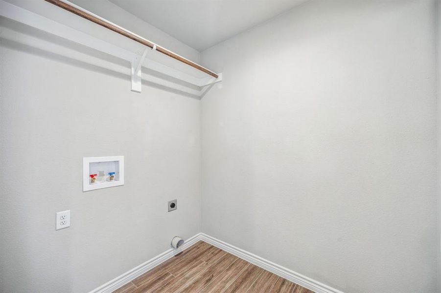 Washroom featuring washer hookup, electric dryer hookup, and hardwood / wood-style flooring