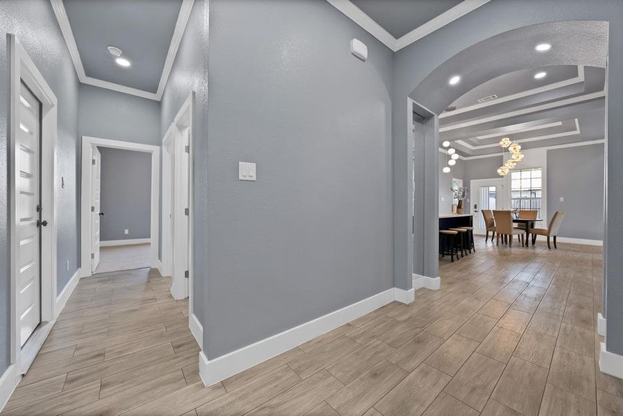 Hallway featuring wood-finish flooring, recessed lighting, and crisp white trim