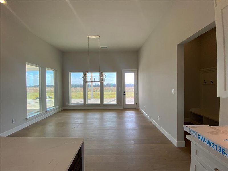 Unfurnished dining area with light wood finished floors and a chandelier