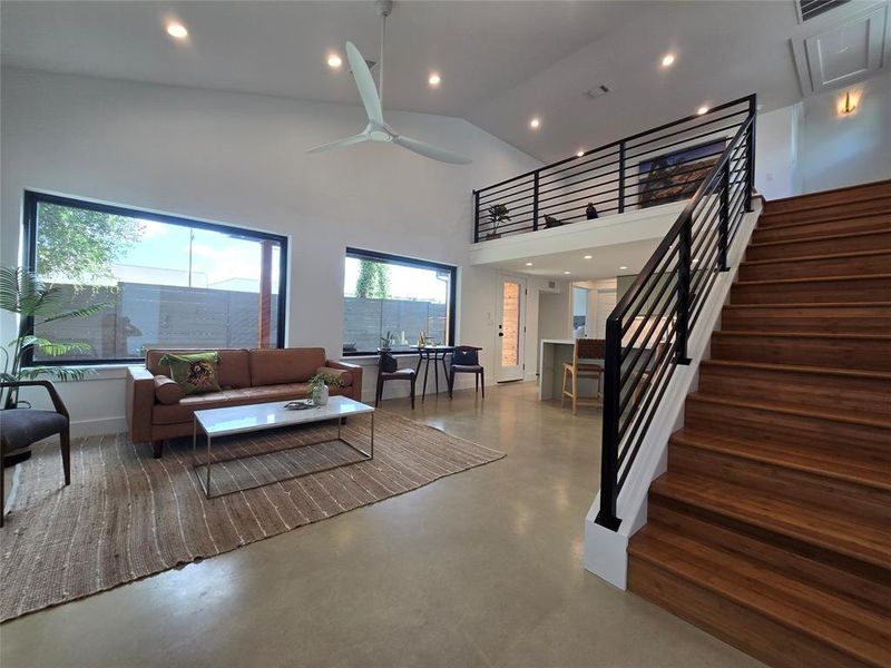 Huge open living room with lots of windows and an open loft looking out to the living space.