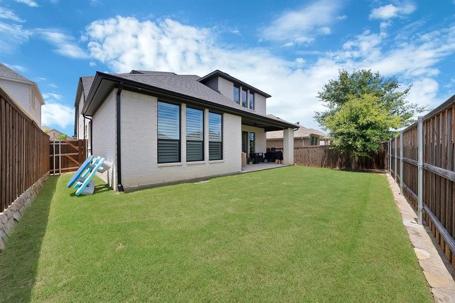 Spacious backyard featuring a lush lawn and perimeter wood fencing Spacious backyard featuring a lush lawn and perimeter wood fencing