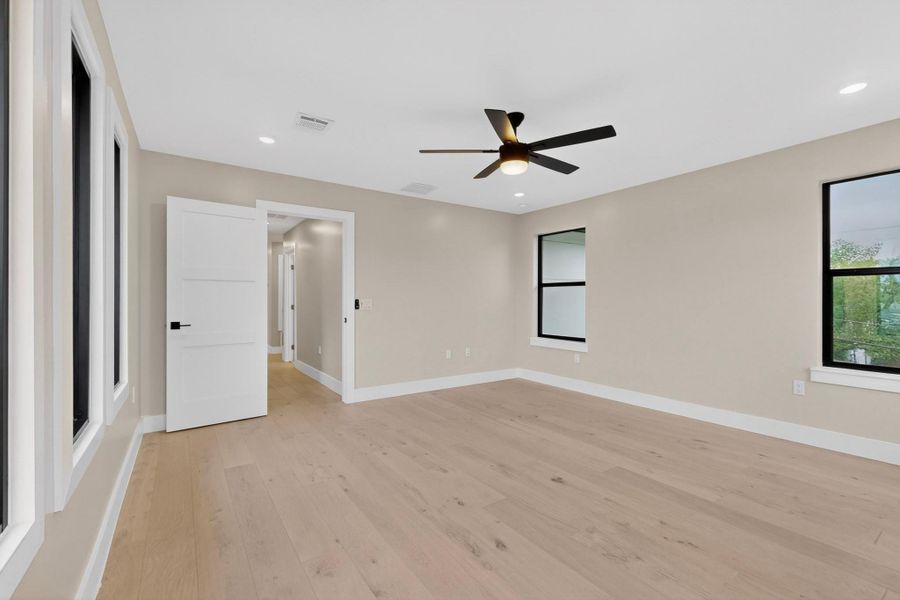 Blonde hardwood floors flow through this peaceful, well-lit space with a contemporary ceiling fan.