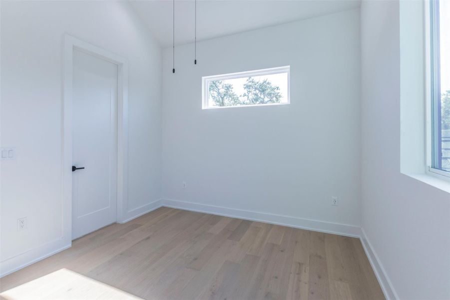 Unfurnished room featuring light wood-type flooring and baseboards