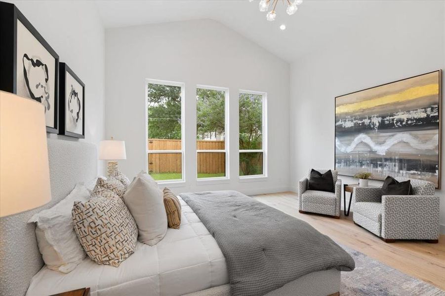 Bedroom featuring light hardwood / wood-style floors, vaulted ceiling, and a notable chandelier