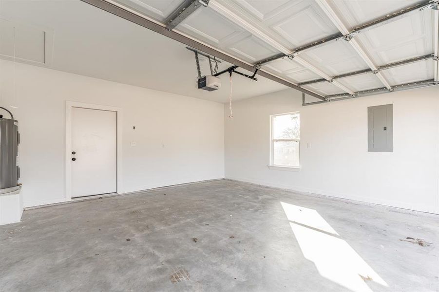 Garage featuring a garage door opener and electric panel