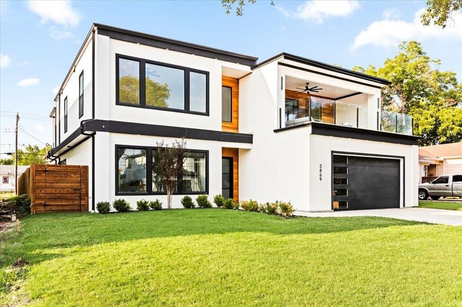 Contemporary home with a garage, a front lawn, and ceiling fan