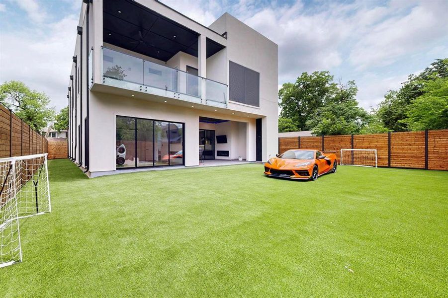 Rear view of house featuring stucco siding, a balcony, a fenced backyard, and a patio area Rear view of house featuring stucco siding, a balcony, a fenced backyard, and a patio area