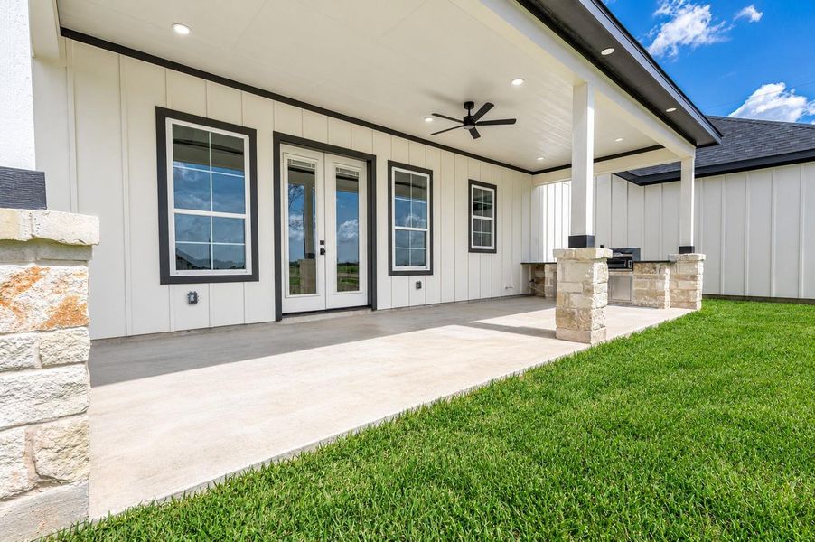 Covered back patio featuring an outdoor kitchen, ceiling fan, and plenty of space for relaxing or entertaining. Covered back patio featuring an outdoor kitchen, ceiling fan, and plenty of space for relaxing or entertaining.