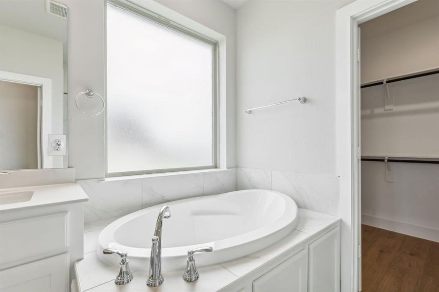 Bathroom featuring hardwood / wood-style floors, vanity, and a wealth of natural light