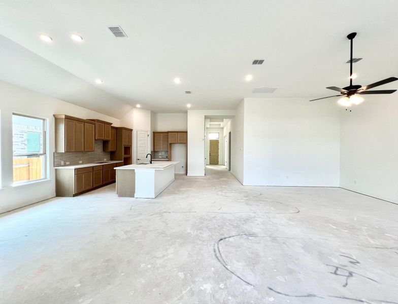 Kitchen featuring open floor plan, a kitchen island with sink, decorative backsplash, brown cabinetry, and recessed lighting Kitchen featuring open floor plan, a kitchen island with sink, decorative backsplash, brown cabinetry, and recessed lighting