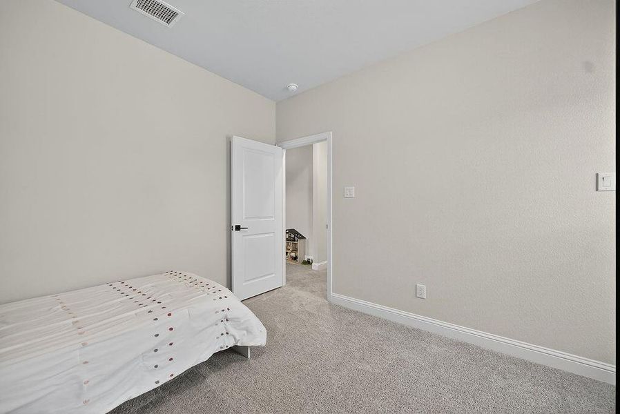 Neutral painted walls with white trim and grey carpet flooring