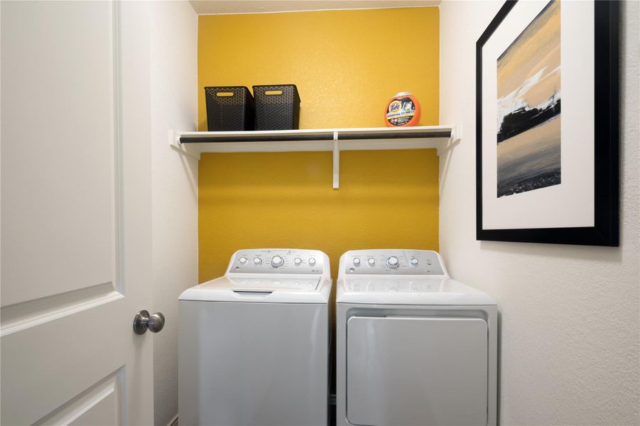 Laundry area featuring washing machine and dryer and a textured wall