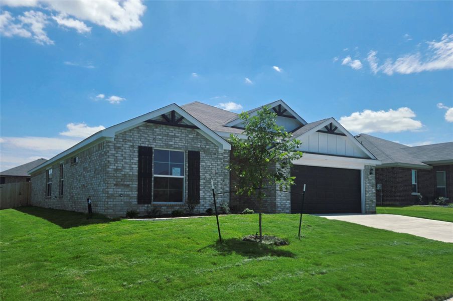 A newly constructed single-story residence boasts an attached garage and a neatly maintained lawn.