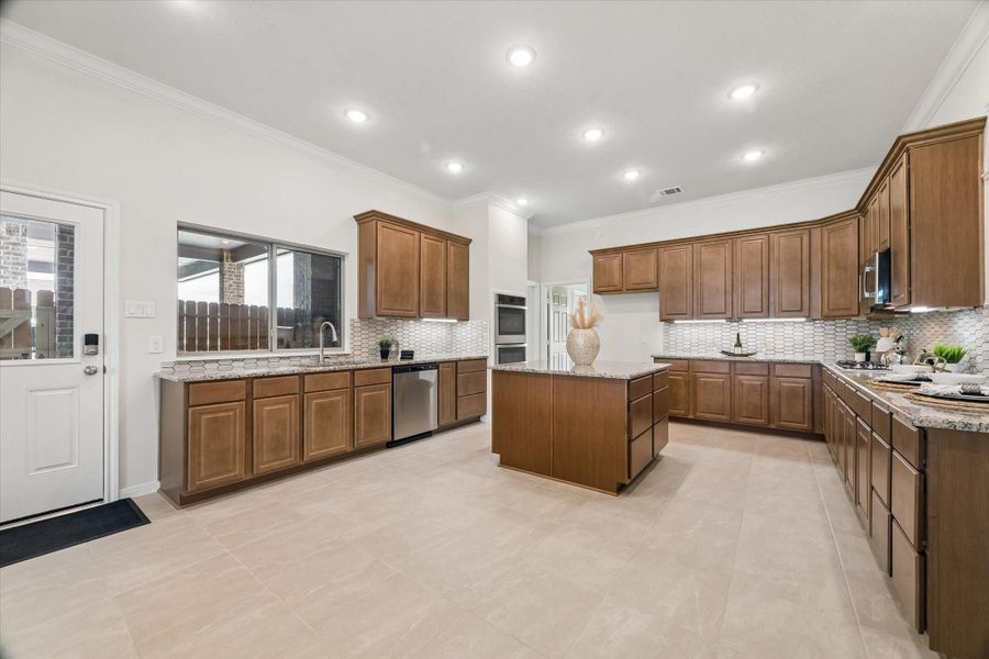 Spacious island kitchen w/ double ovens, stainless steel appliances & granite counters