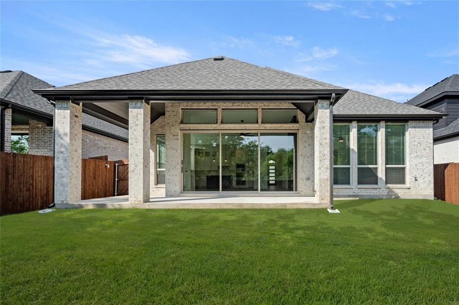 Back of property with roof with shingles, a patio area, and brick siding
