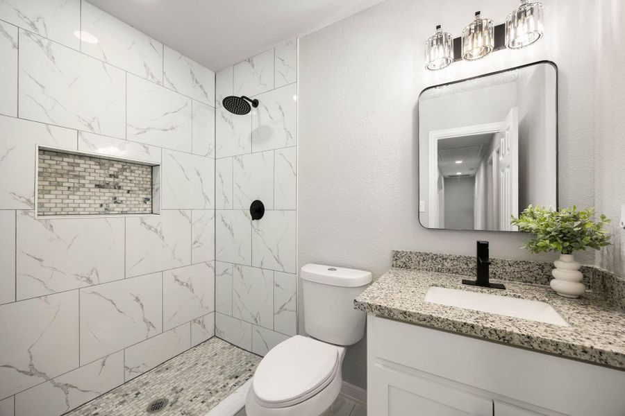 This guest bathroom features modern fixtures, tasteful tile work, and a clean, inviting design that perfectly complements the home's aesthetic. This guest bathroom features modern fixtures, tasteful tile work, and a clean, inviting design that perfectly complements the home's aesthetic.