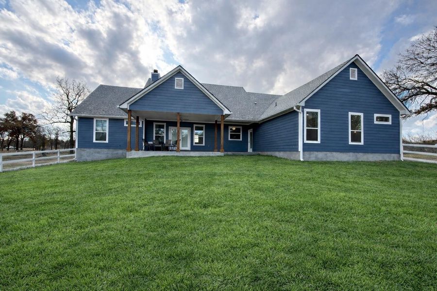 Back of property with a chimney, a patio area, and roof with shingles Back of property with a chimney, a patio area, and roof with shingles