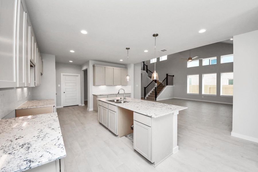 This kitchen is truly a chef's dream! This haven Boasts high ceilings, recessed & pendant lighting, stained wood cabinets, granite countertops, stainless steel appliances, a modern tile backsplash. All of this overlooks your expansive family room, creating a perfect space for culinary delights and family gatherings. Sample photo of completed home with similar floor plan. Actual colors and selections may vary. This kitchen is truly a chef's dream! This haven Boasts high ceilings, recessed & pendant lighting, stained wood cabinets, granite countertops, stainless steel appliances, a modern tile backsplash. All of this overlooks your expansive family room, creating a perfect space for culinary delights and family gatherings. Sample photo of completed home with similar floor plan. Actual colors and selections may vary.