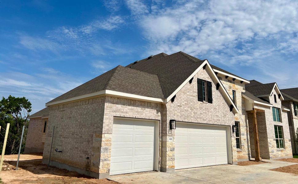 View of side of property featuring brick siding, a shingled roof, and driveway View of side of property featuring brick siding, a shingled roof, and driveway