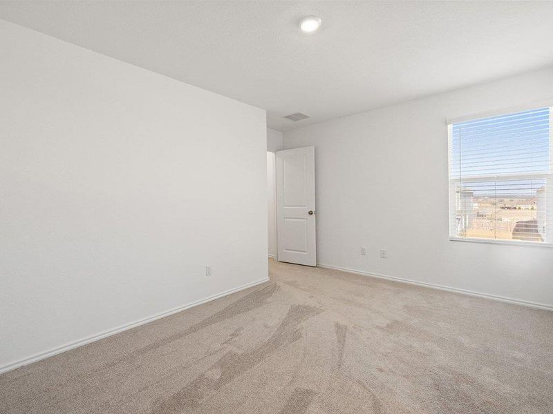 Carpeted spare room featuring baseboards